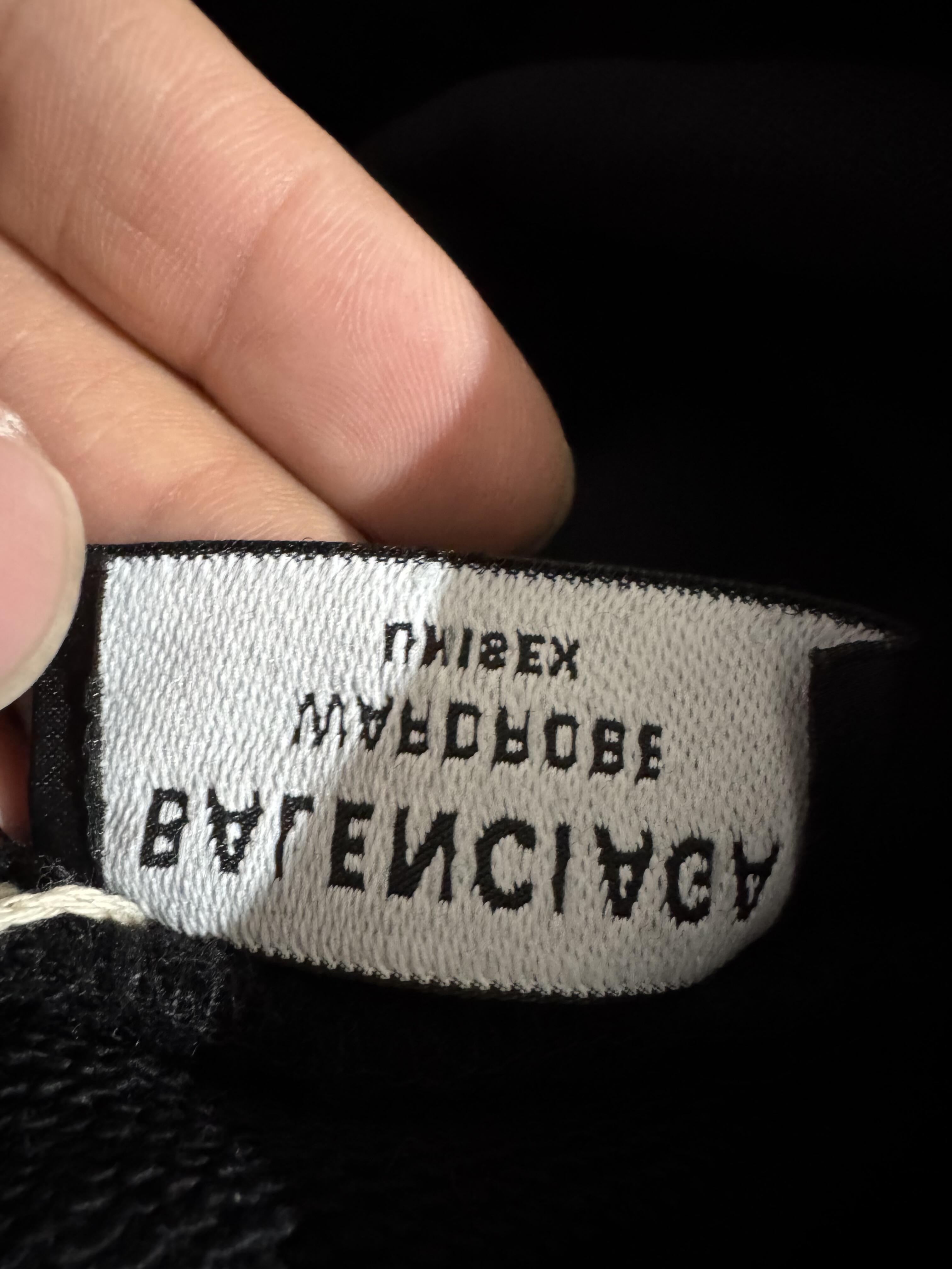 A dramatic shot of a high-end designer security tag and barcode on a counterfeit item, illustrating the betrayal of receiving a fake from a trusted site.