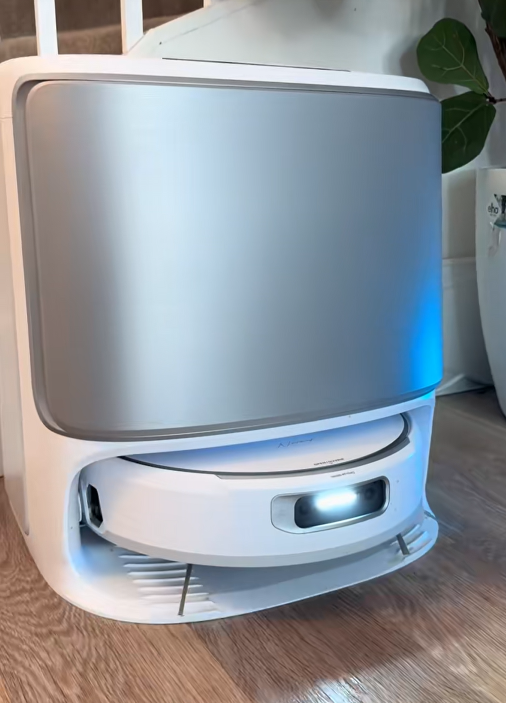 A Narwal Flow robot vacuum base station displaying a notification on its screen, indicating a firmware update status or alert.