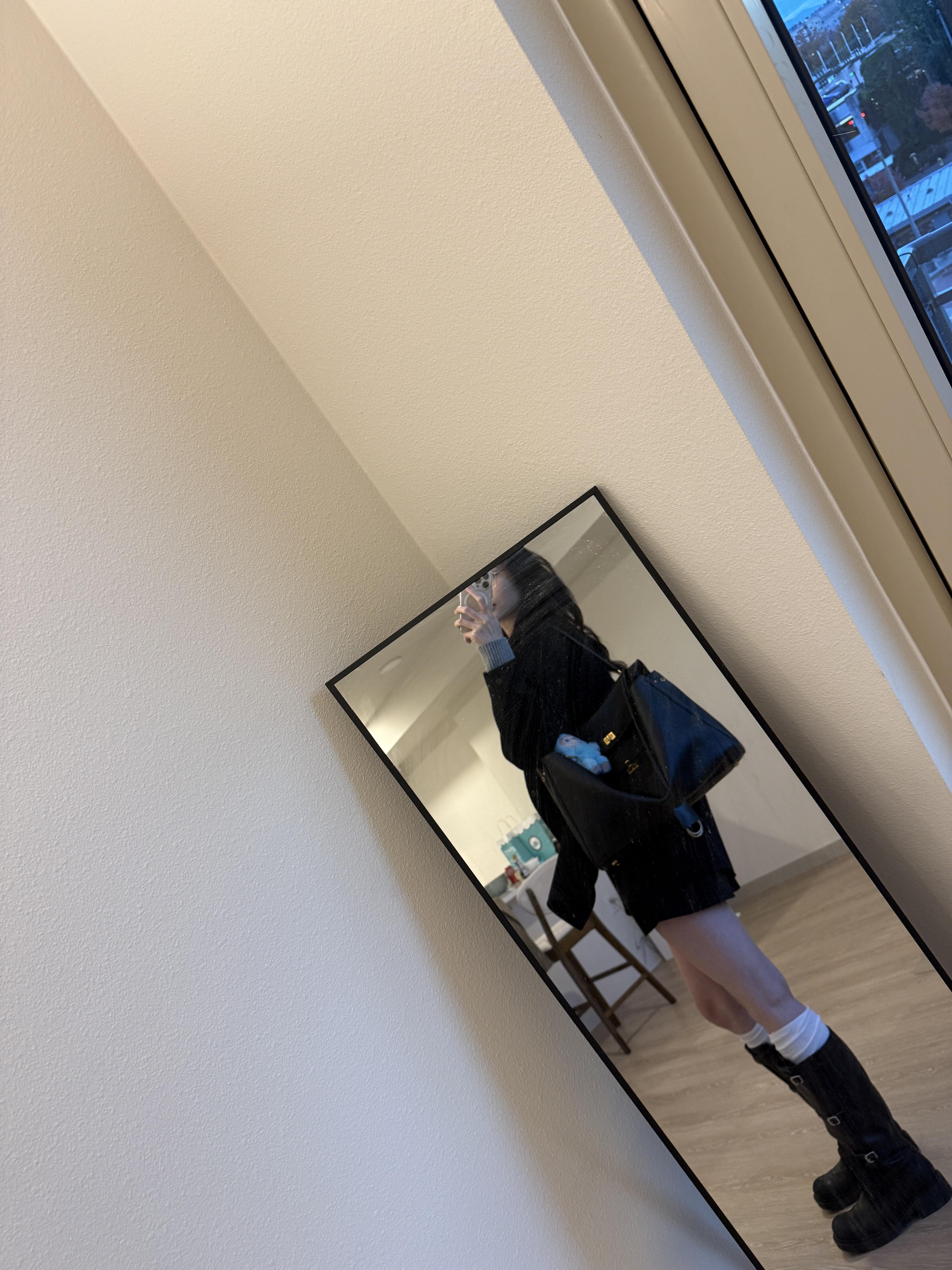 A stylish flat lay featuring the Balenciaga Rodeo Large alongside a luxury wallet and a smartphone, hinting at the high cost and investment of the bag.