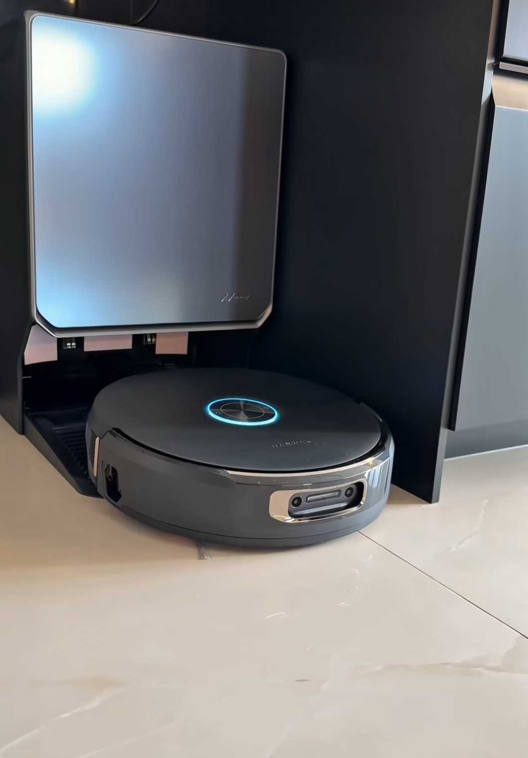 A close-up view of a robot vacuum's internal plastic dustbin completely jammed with packed dog and cat fur