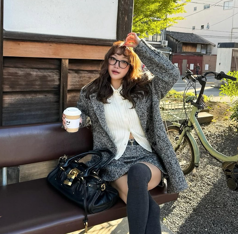 Japanese fashion blogger carrying a dark Chloé Paddington bag.